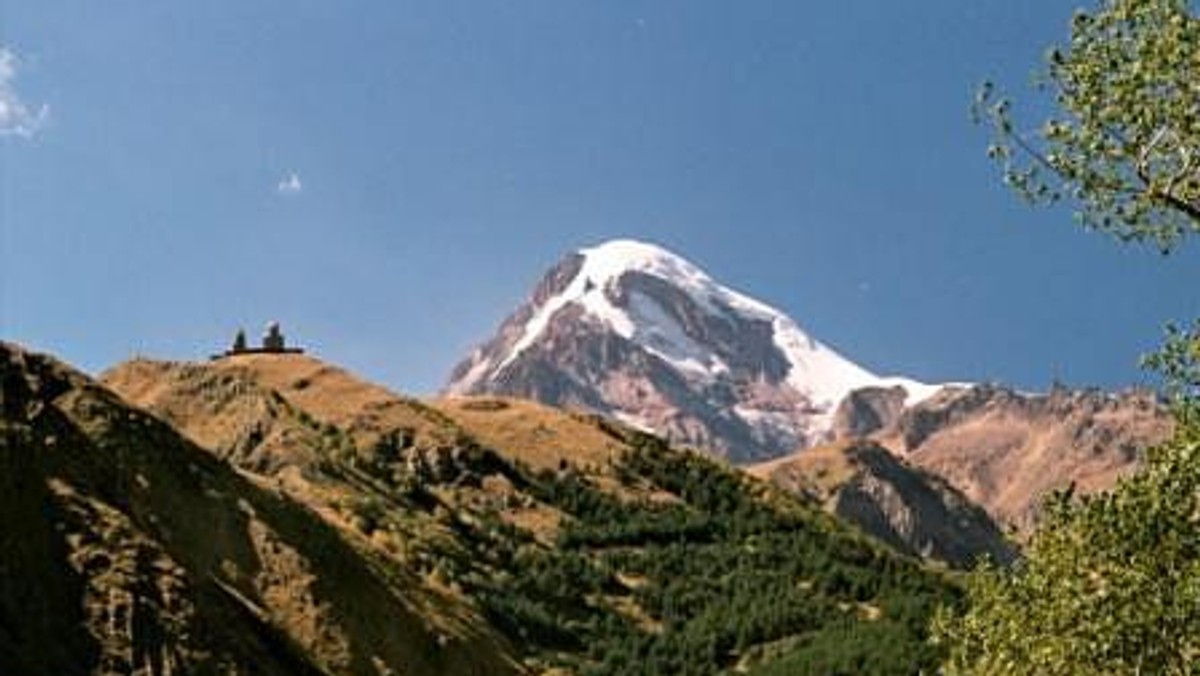 Zamarzył mi się pięciotysięcznik i oto mam go przed sobą! Na tle bezchmurnego nieba nieskazitelną bielą lśni wierzchołek Kazbeka (5047 m n.p.m.), jednego z najwyższych szczytów Kaukazu Wysokiego. Umordowana kilkudziesięciogodzinną podróżą (autokarem do Rygi, stamtąd samolotem do Tbilisi i wreszcie wynajętą  marszrutką do Kazbegi) wciąż nie mogę uwierzyć, że już jutro zacznie się nasza przygoda z Wielką Górą.