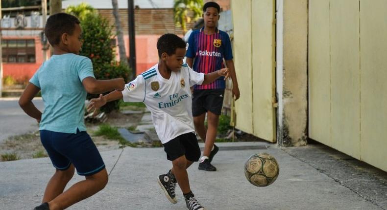 Cuban children play soccer in a street in Havana, where the beautiful game is threatening to topple baseball as the island's most popular sport