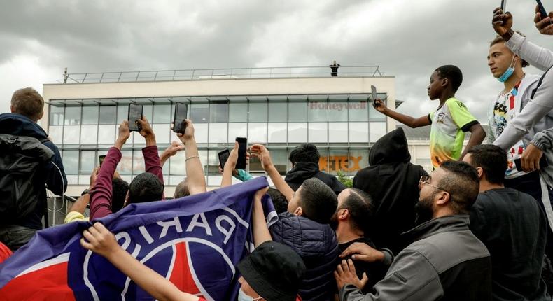Expectant PSG supporters gather at Le Bourget airport just outside Paris on Monday, waiting for the possible arrival of Lionel Messi