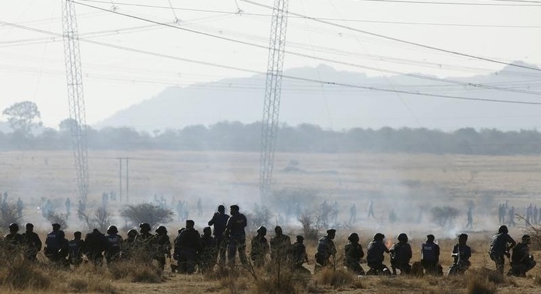 Policemen fire at striking miners outside a South African mine in Rustenburg, 100 km (62 miles) northwest of Johannesburg, August 16, 2012. 