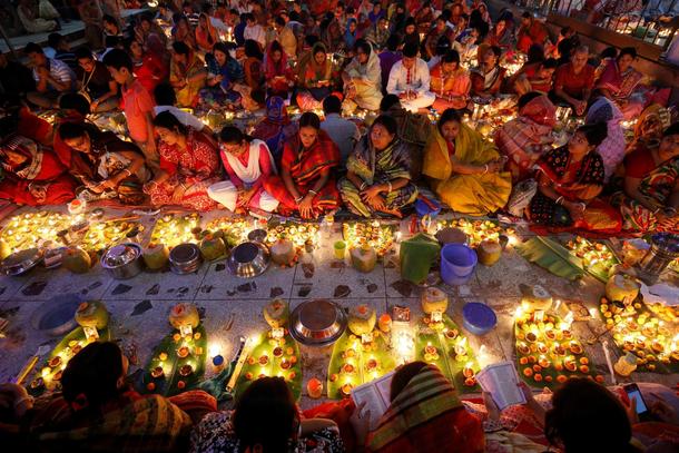 Hindu devotees sit together on the floor of a temple to observe Rakher Upabash for the last day, in 
