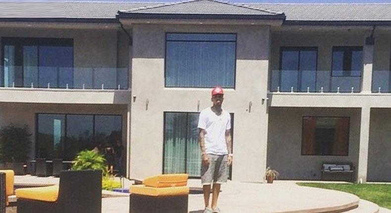 Chris Brown standing in front of his new home