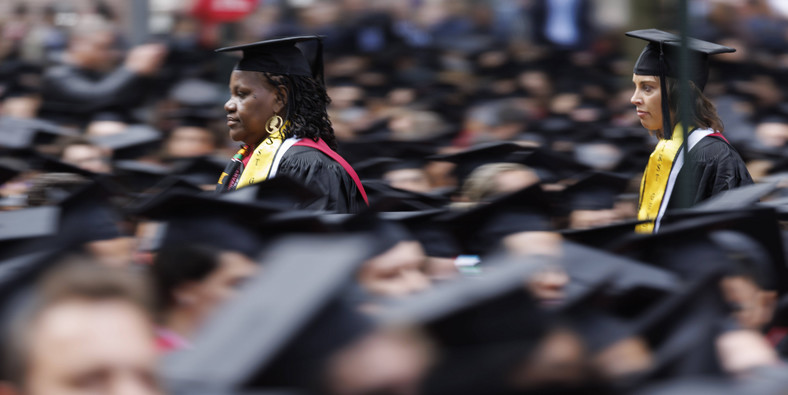 Absolwenci przeciskają się przez tłum podczas ceremonii odebrania dyplomów na Uniwersytecie Harvarda w Cambridge, Massachusetts, USA, 25 maja 2023 r.