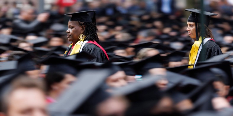 Absolwenci przeciskają się przez tłum podczas ceremonii odebrania dyplomów na Uniwersytecie Harvarda w Cambridge, Massachusetts, USA, 25 maja 2023 r.