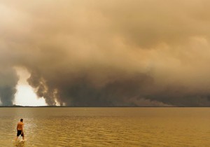 Posetioci plaže odmaraju se na plaži Mučik na obali jezera Lakano u Lakanou, na jugozapadu Francuske, dok požar besni u Žirondi, 24. jul 2026.