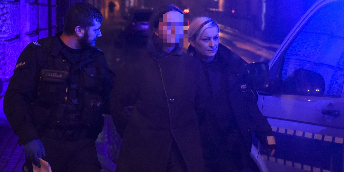 Policjanci wyprowadzają z banku obezwładnioną przez świadków 25-latkę.