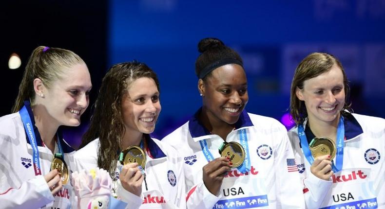 USA's Katie Ledecky, Mallory Commerford, Kelsi Forrel and Simone Manuel celebrate on the podium after winning the women's 4x100m freestyle relay in Budapest, on July 23, 2017