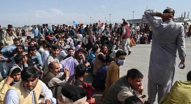 A crowd of mostly men gathers on the tarmac of Kabul airport on August 16, 2021.
