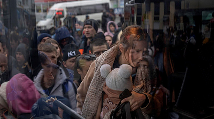 Gyermekét tartó nő felszáll egy buszra Kijevben, hogy elhagyja a várost 2022. február 24-én/ Fotó: MTI/AP/Emilio Morenatti