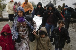 Migrants walk under rain after crossing the border from Greece into Macedonia, near Gevgelija