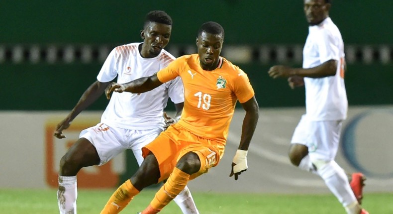 Ivory Coast forward Nicolas Pepe (C) controls the ball with Niger midfielder Mahamane Cisse behind him during an Africa Cup of Nations qualifier in Abidjan Saturday