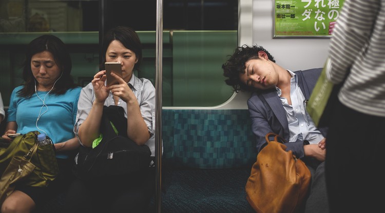 Japán férfi alszik a metrón.