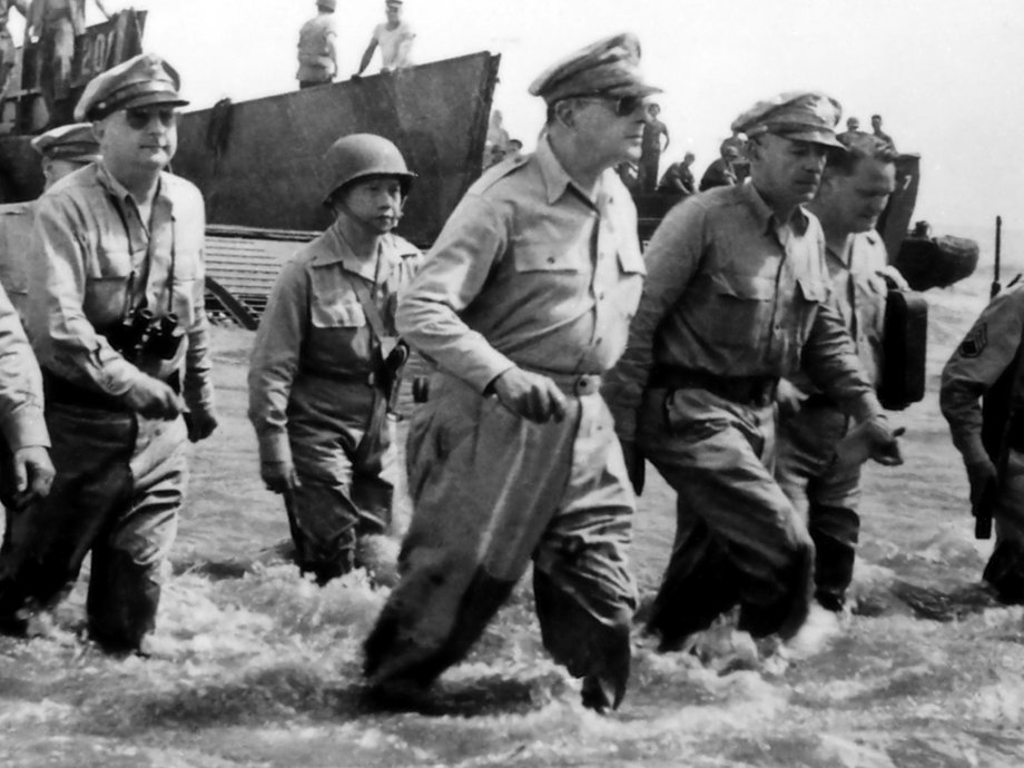 General Douglas MacArthur wades through the water after landing on a beach in the Philippines in 1944.