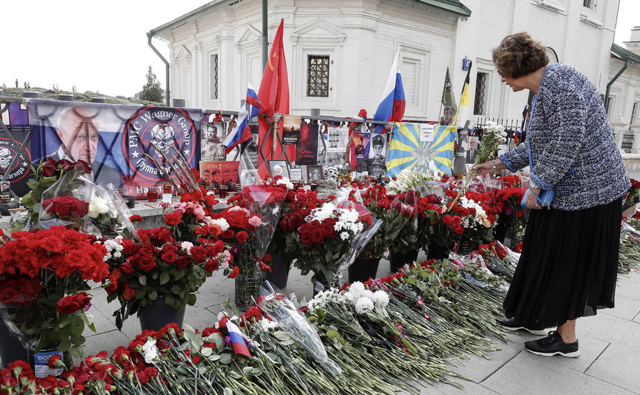 Kobieta składa kwiaty pod nieformalnym pomnikiem ku czci szefa Grupy Wagnera Jewgienija Prigożyna w Moskwie, Rosja, 28 sierpnia 2023 r.