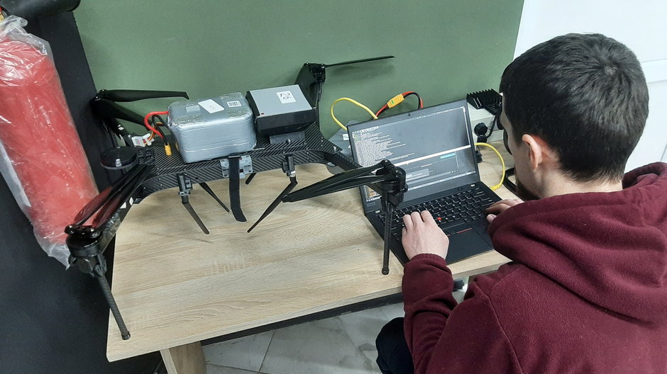 Inżynier wgrywa oprogramowanie do systemu drona.