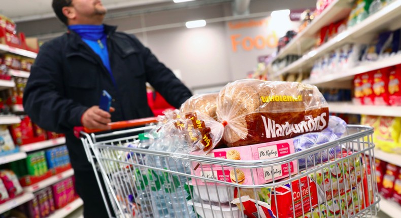 A shopper pushes a trolley in a supermarket in London