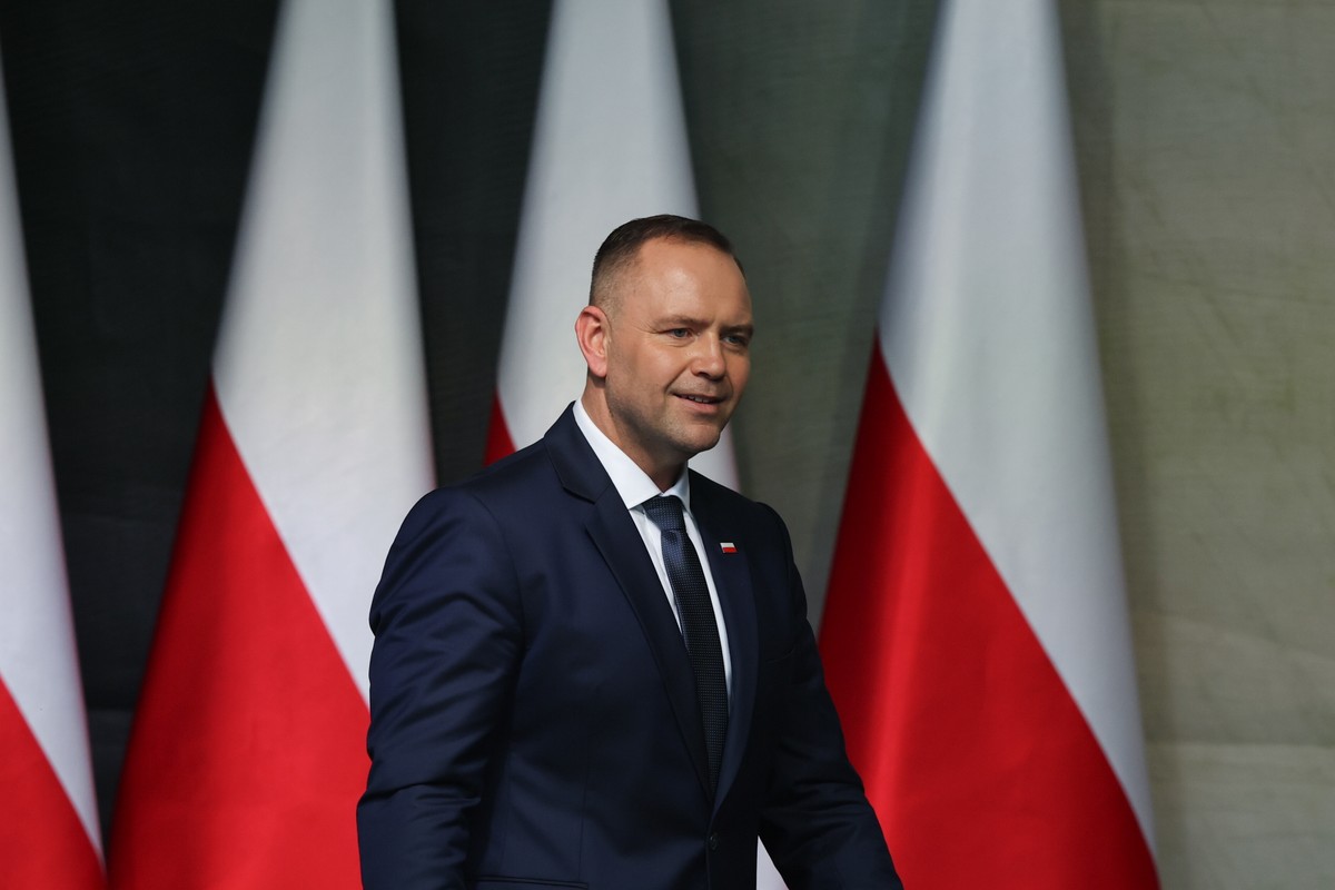 Prezydent Karol Nawrocki na tle flag Polski