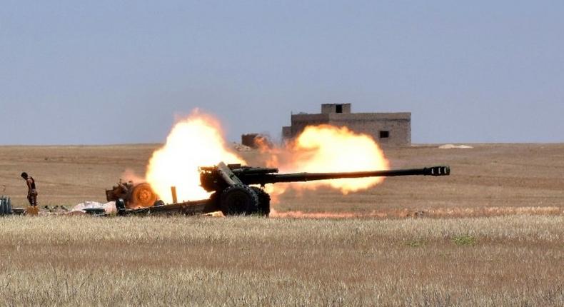Syrian government forces fire artillery during a battle against the Islamic State group on May 16, 2017 on the edge of Lake Assad in the eastern part of Aleppo province