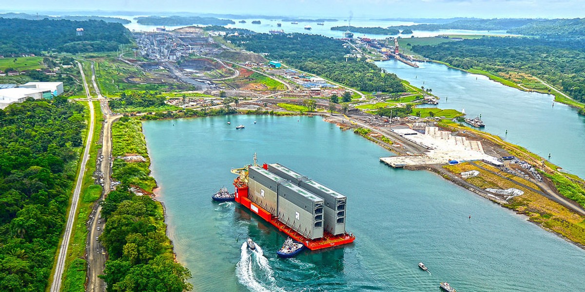 Two massive iron gates being moved into position at the site of a new lock, part of a $5.25 billion expansion of the Panama Canal.