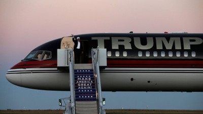 Republican presidential nominee Donald Trump waves as he walks off his plane at a campaign rally in 