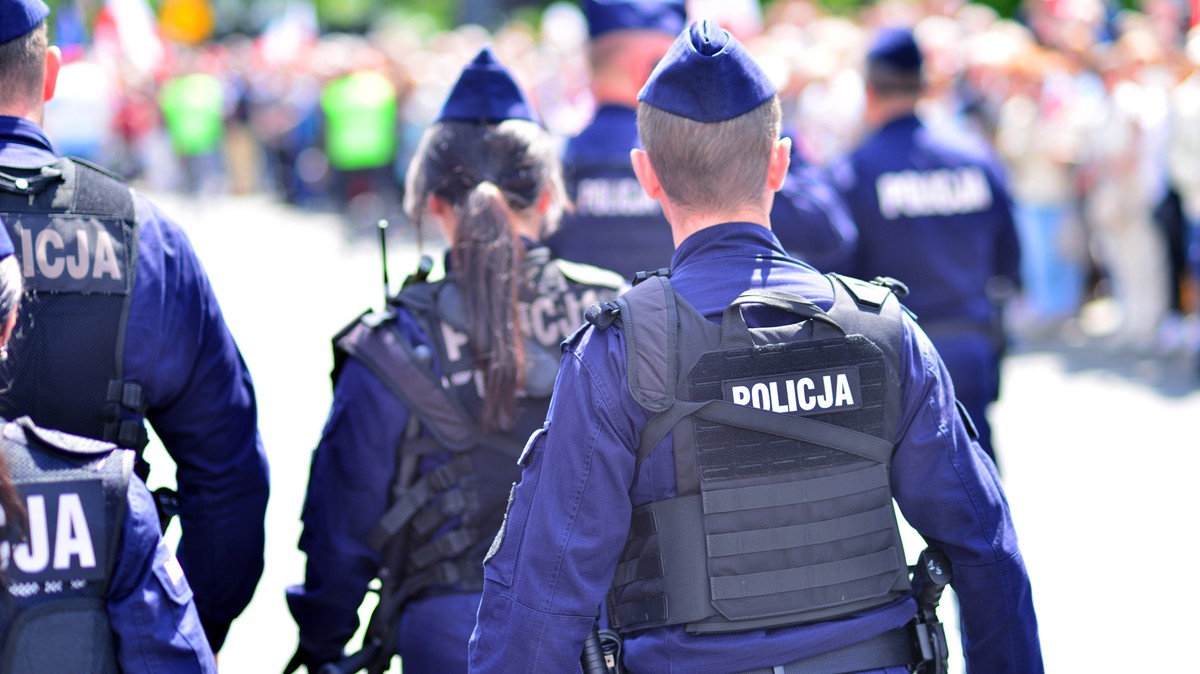 Policjanci i policjantka idący po mieście