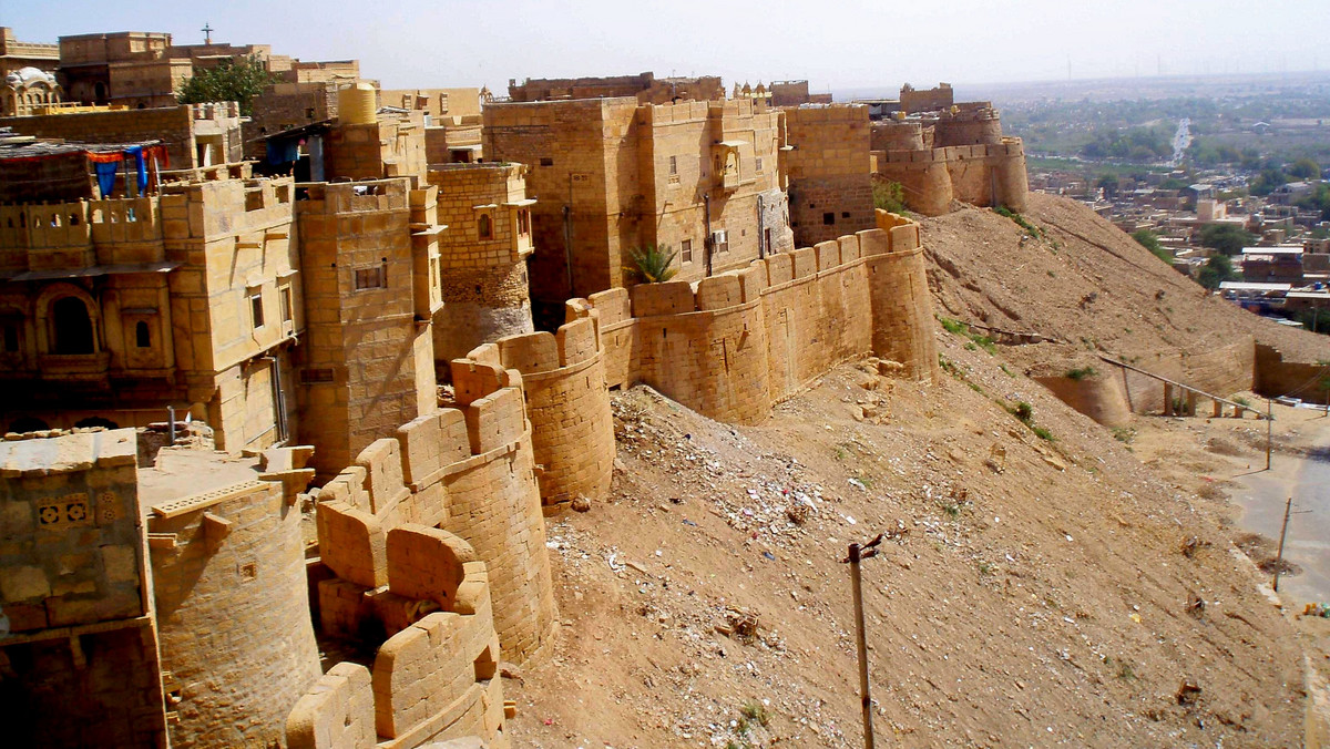 Fort Jaisalmer w Radżastanie, położony na pustyni Thar na zachodzie Indii, przypomina wielki zamek z piasku zbudowany na plaży. Taki ze wspomnień dziecięcych, który złośliwe fale morskie potrafiły zburzyć. Ludzie pustyni z reguły modlą się o deszcz, bo on ratuje życie. Nie w Jaisalmerze, zwanym „Złotym Miastem”. Tu woda, a przede wszystkim niewłaściwe nią gospodarowanie, niszczy perłę architektury.