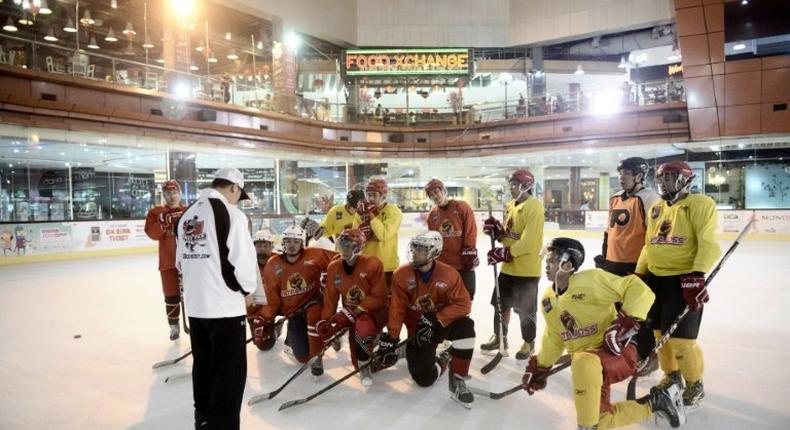 Indonesian ice hockey team players listen to their Malaysian coach Gary Tan (L in white) at a skating rink in South Tangerang, ahead of the Asian Winter Games in Sapporo