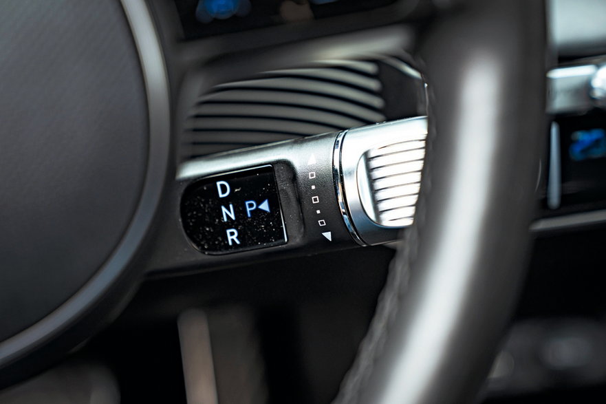 Hyundai Ioniq 5 2022 - dźwignia wyboru trybów pracy napędu przy kierownicy. Prawie, jak w Mercedesie, którego niedawno Hyundai pokonał w porównaniu elektryków.