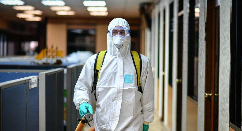 A Thai cleaner sprays disinfectant inside a meeting room of a Bangkok office as a preventive measure against the novel corona virus.