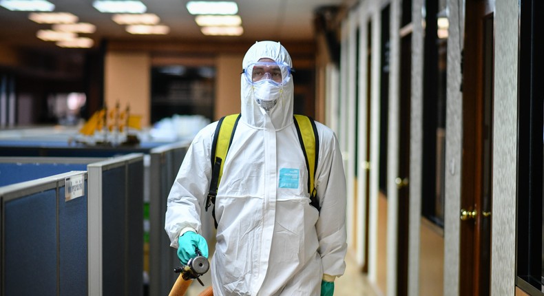 A Thai cleaner sprays disinfectant inside a meeting room of a Bangkok office as a preventive measure against the novel corona virus.