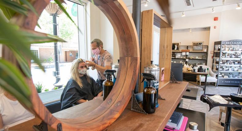 FILE- In this June 1, 2020, file photo hair stylist Zak Moukhtabir works on the hair of Cheyenne Foster at the Georgetown Salon & Spa in Washington.  The Trump administration does not have to issue an emergency rule requiring employers to protect workers from the coronavirus, a federal appeals court ruled Thursday, June 11. (AP Photo/Manuel Balce Ceneta, File)