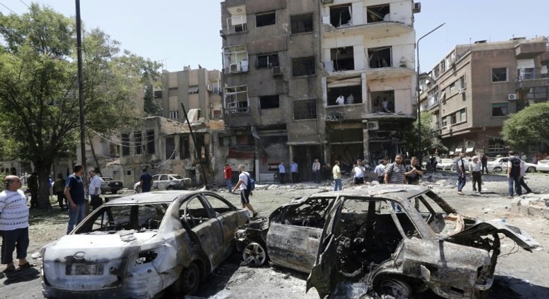 Charred vehicles are seen on the site of a suicide bomb attack in the Syrian capital's eastern Tahrir Square district, on July 2, 2017