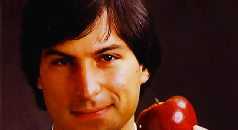 Steve Jobs holding an Apple