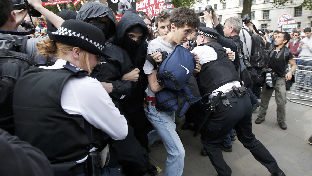 Demonstrators faces off with police during protest after the State Opening of Parliament in central London