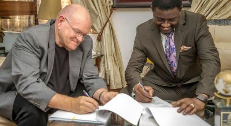 Bishop Mills and Bishop Charles Agyinasare signing the takeover documents