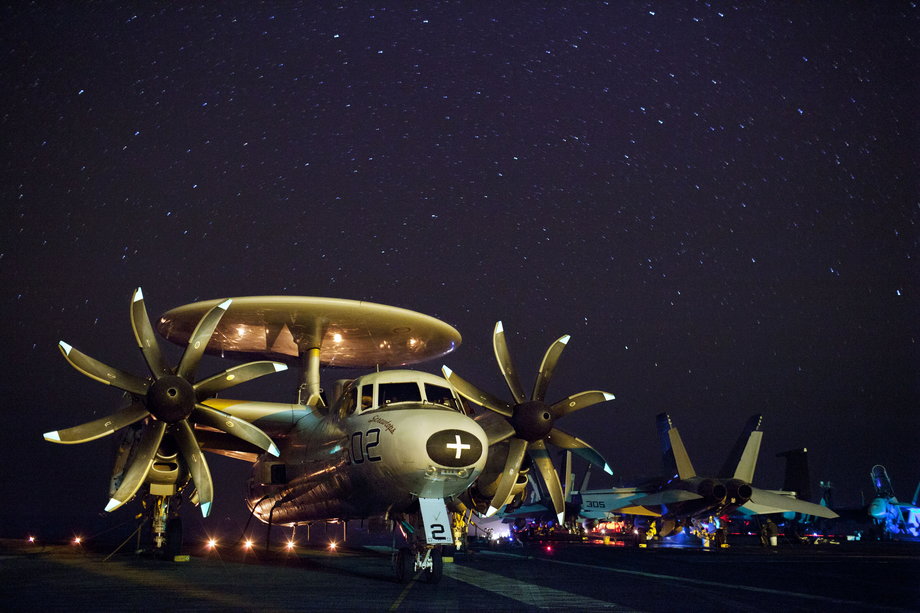 An E-2C Hawkeye assigned to Carrier Air Wing 1 sits on the flight deck of USS Enterprise at night. Enterprise is deployed to the US 5th Fleet area of responsibility conducting maritime security operations, theater-security cooperation efforts, and support missions as a part of Operation Enduring Freedom.