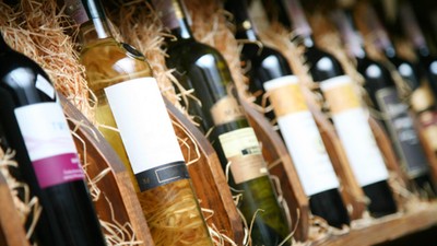 Closeup shot of wineshelf. Bottles lay over straw.