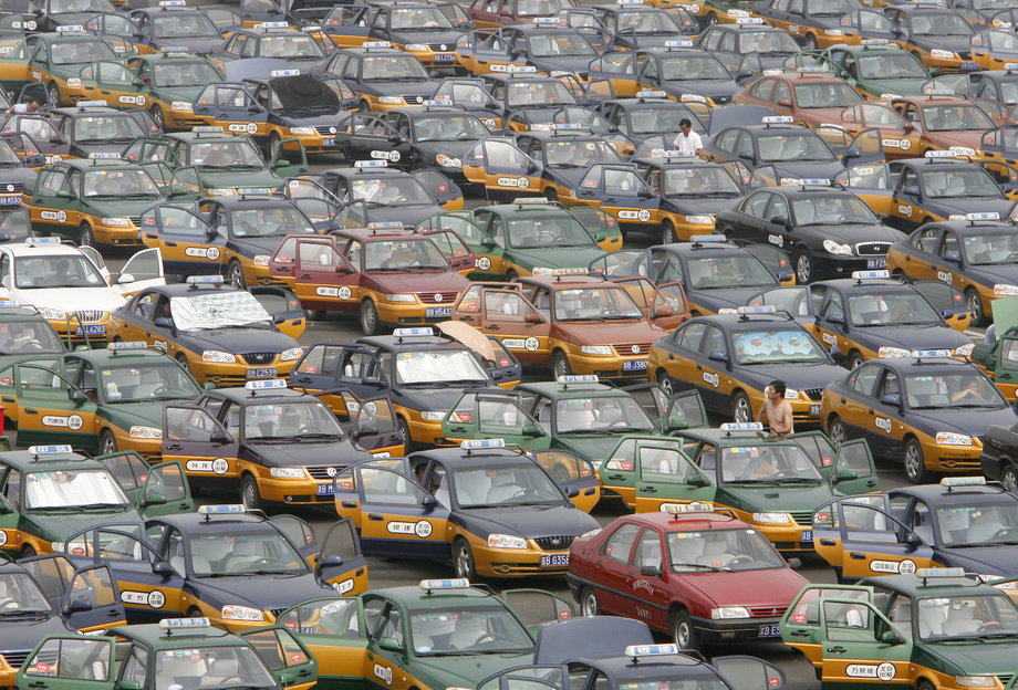 Taksówkarze stojący na parkingu podczas oczekiwania na pasażerów na lotnisku w Pekinie.