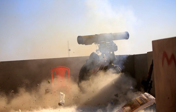 A member of Iraqi rapid response forces fires a weapon towards Islamic State militants in Antesaar n