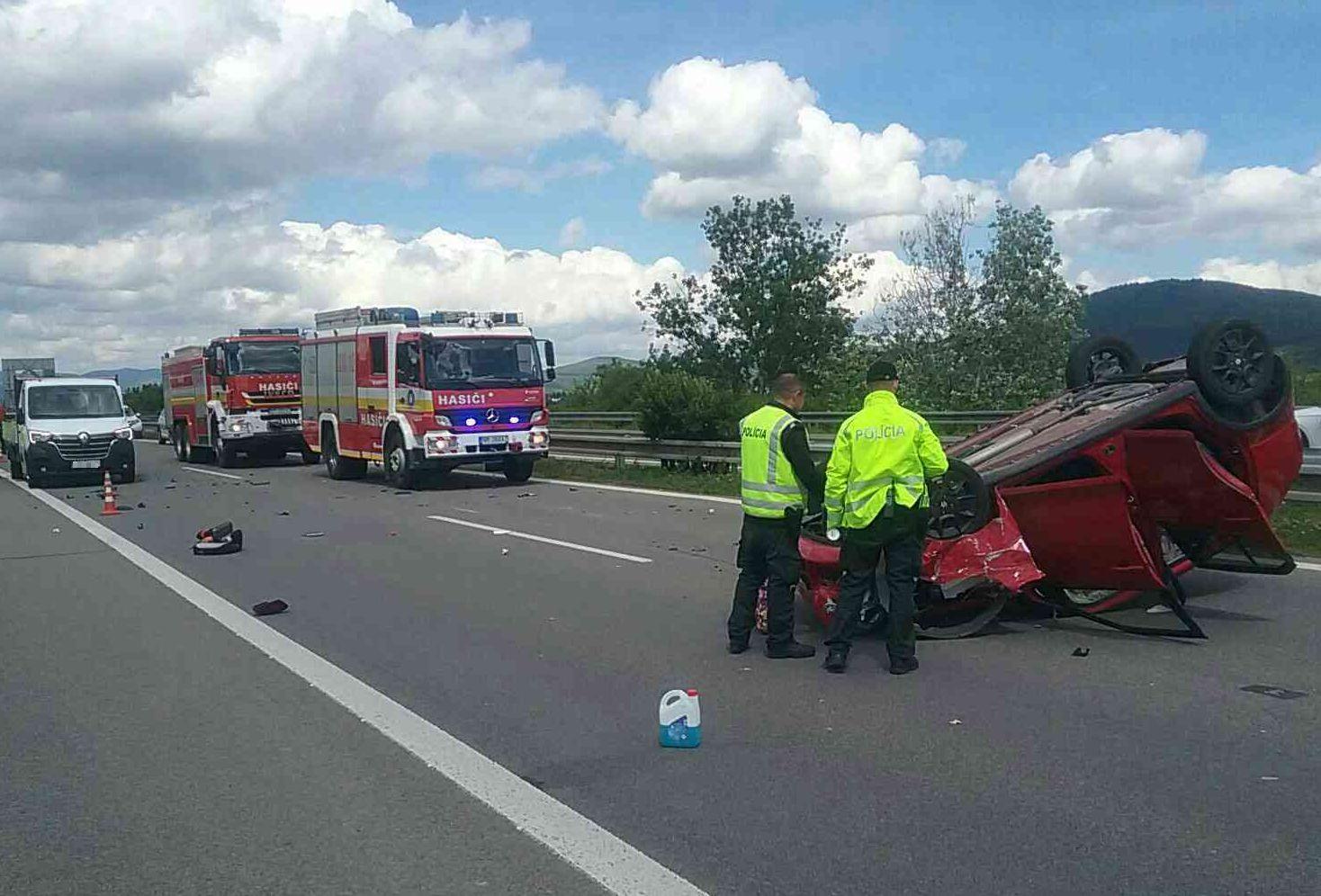 Po nehode troch vozidiel na diaľnici zostalo auto prevrátené na strechu.