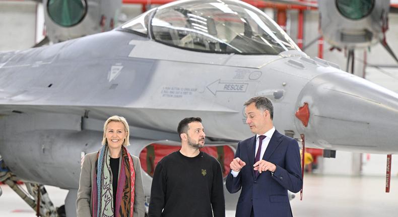 Belgian Defense Minister Ludivine Dedonder, Ukrainian President Volodymyr Zelenskyy, and Belgian Prime Minister Alexander De Croo stand in front of an F-16 at Melsbroek military airport, Tuesday, 28 May 2024.ERIC LALMAND/BELGA MAG/AFP via Getty Images