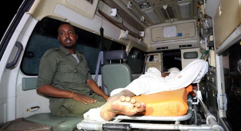 Somali policeman sits inside an ambulance as he guards an Al-Shabaab fighter injured during an exchange of gunfire after a car bomb explosion at the Banadir beach restaurant at Lido beach in Somalia's capital Mogadishu, August 25, 2016. Picture taken August 25, 2016. REUTERS/Feisal Omar