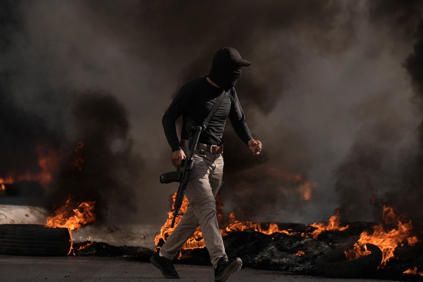 Palestinski militant beži tokom sukoba sa izraelskim snagama u izbegličkom kampu Dženin na Zapadnoj obali