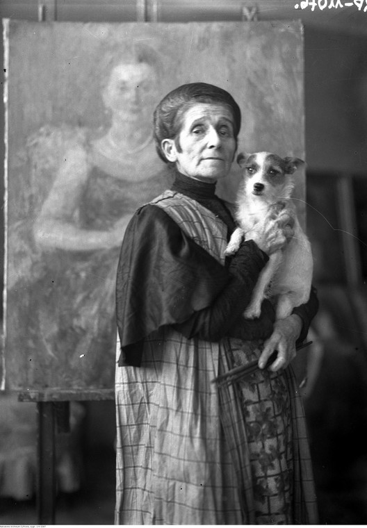 Olga Boznańska w krakowskiej pracowni z pieskiem Kwi-Kwi, w tle "Portret kobiety"