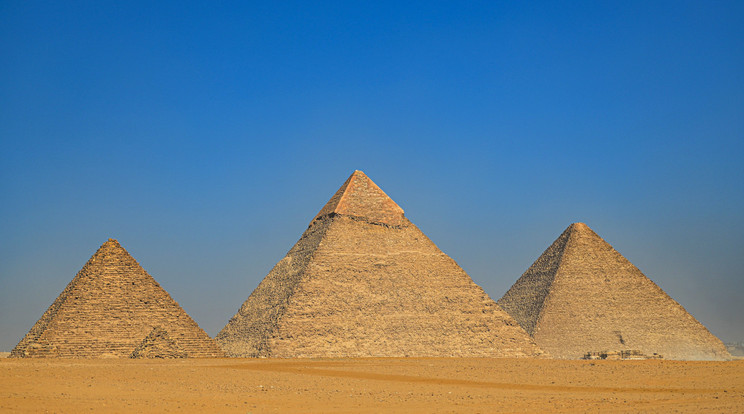 A gízai három nagy piramis, a baloldali Menkaure fáraó nyughelye, amelynek helyreállítása az egyiptológusok között hatalmas felháborodást váltott ki. Az egyiptomi-japán közös munka célja, hogy a következő három év során a piramis burkolatát az eredeti 16 réteg magasságában állítsák helyre, felhasználva a piramis alapja körül felhalmozódott, mára lehullott tömbök egy részét. / Fotó: Getty Images
