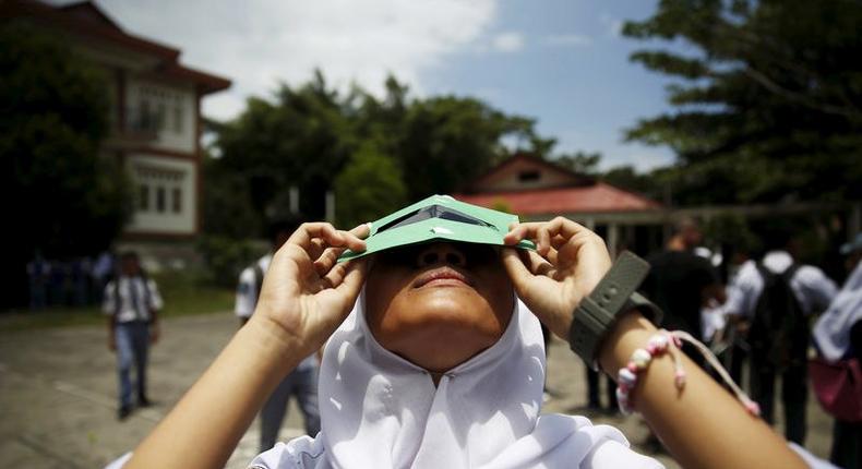 A student testing a self-made filter to view the sun.