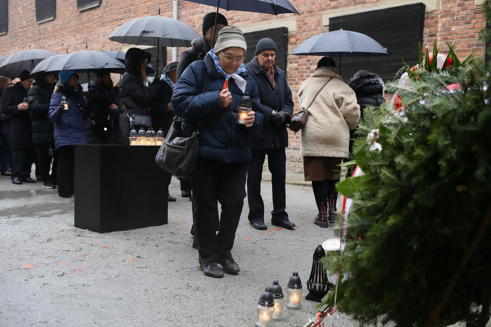 Złożenie kwiatów i zapalenie zniczy przed Ścianą Śmierci na terenie byłego niemieckiego nazistowskiego obozu koncentracyjnego i zagłady Auschwitz-Birkenau w Oświęcimiu