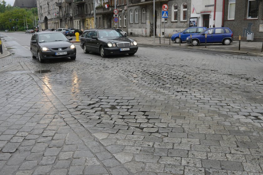 Samochody jadą po drodze z kostki 