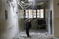 A boy inspects damage inside his school, due to what activists said was an air strike carried out ye