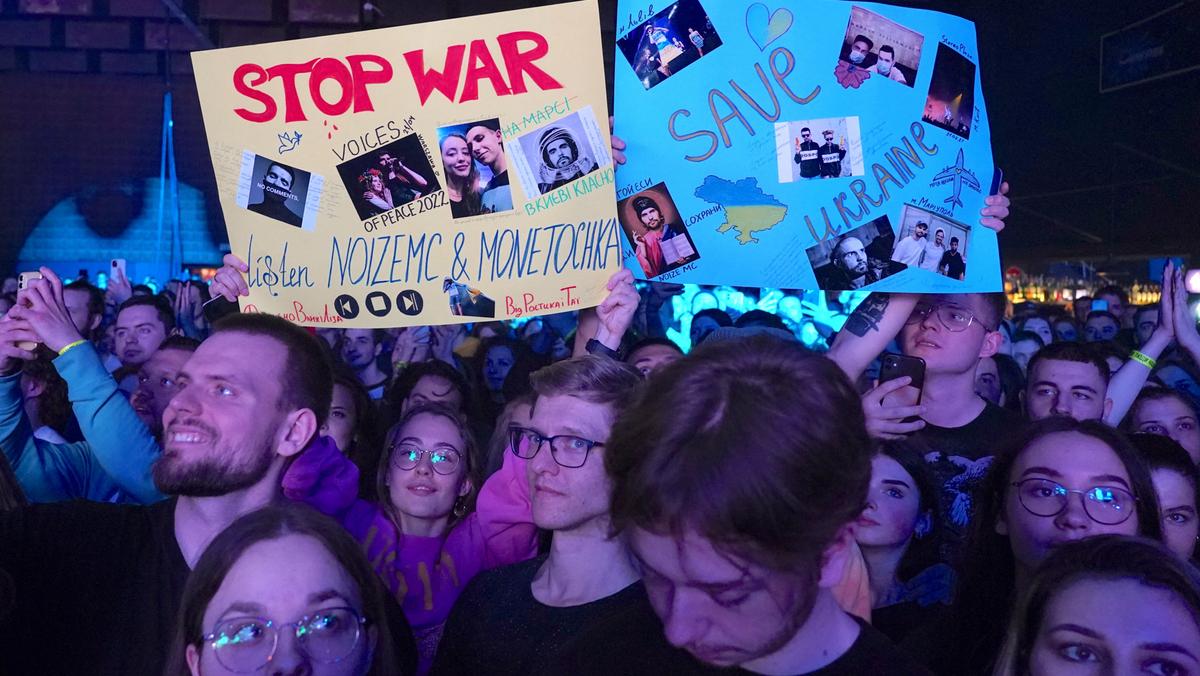 REFUSENIKS Spectators hold up posters during an antiwar concert by Russian musicians Noize MC and Monetochka in Warsaw, Poland, 2022